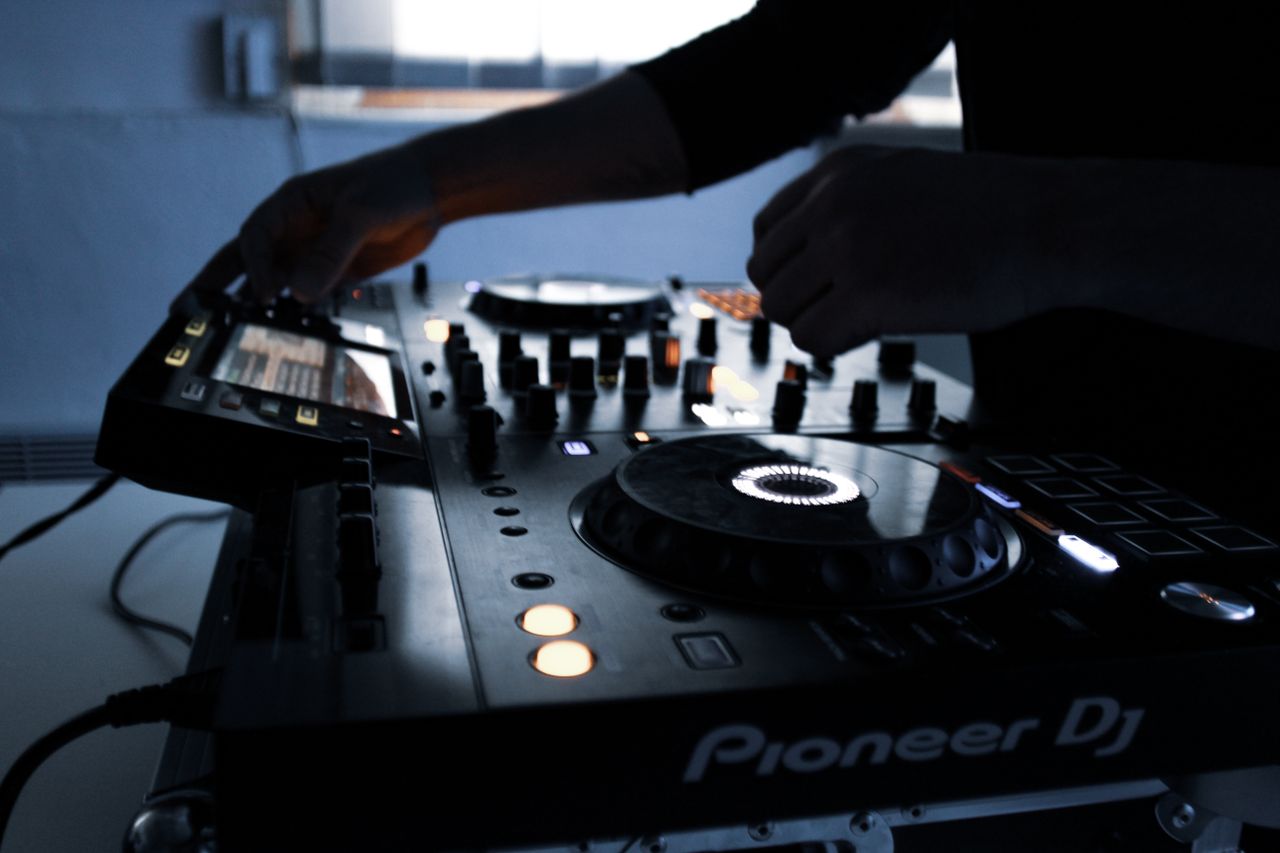 Services Close-up of DJ equipment in action during a mixing session in a dimly lit room.